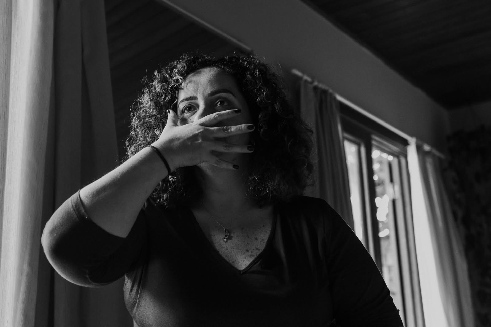 Mulher em uma expressão corporal, com a mão diante da boca
