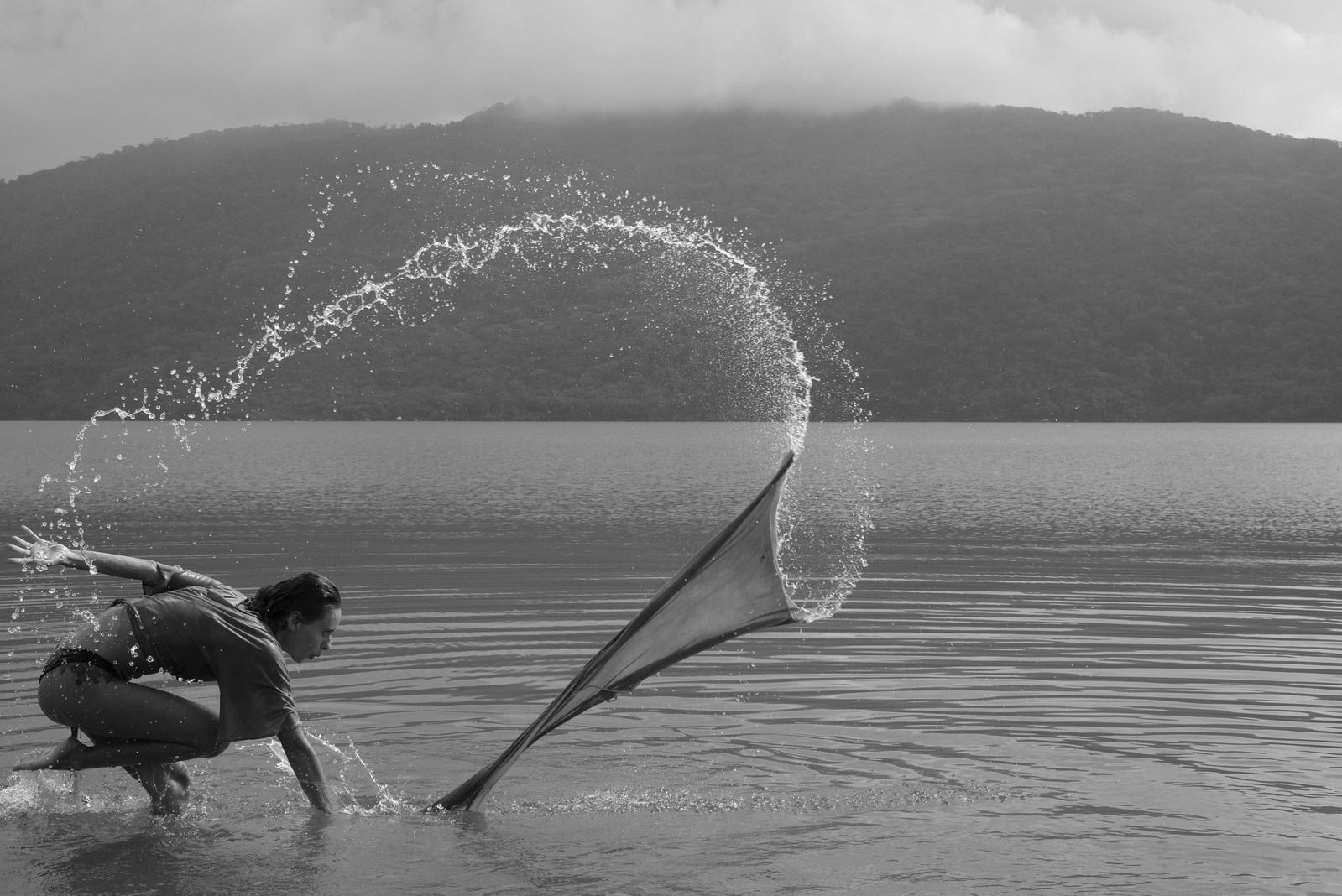 Corpo em movimento lançando água em um arco